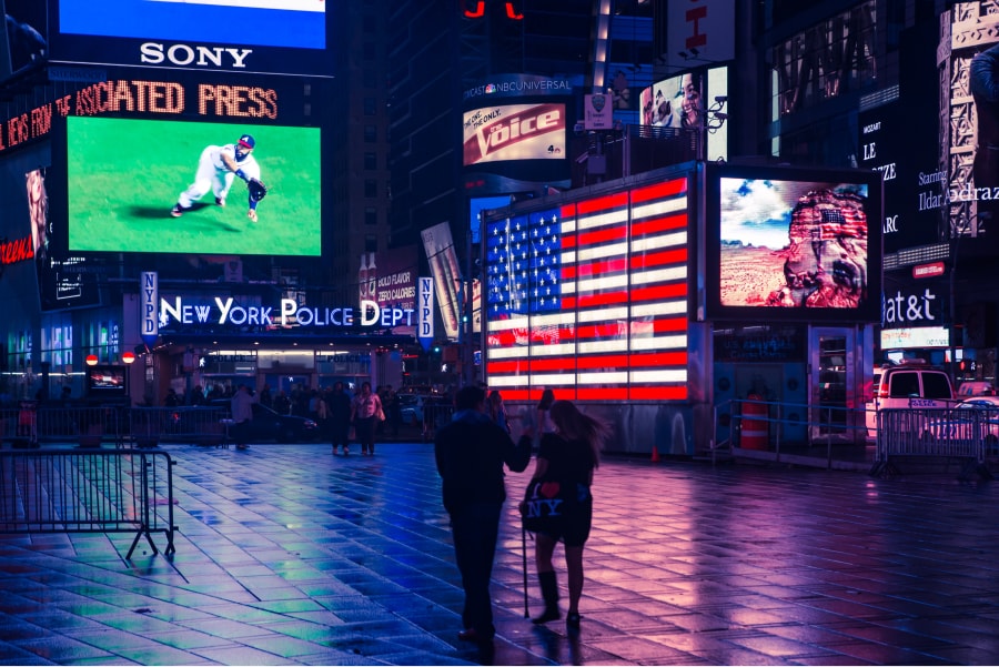 Imagem de rua à noite iluminada com a luz de Displays Digitais exteriores