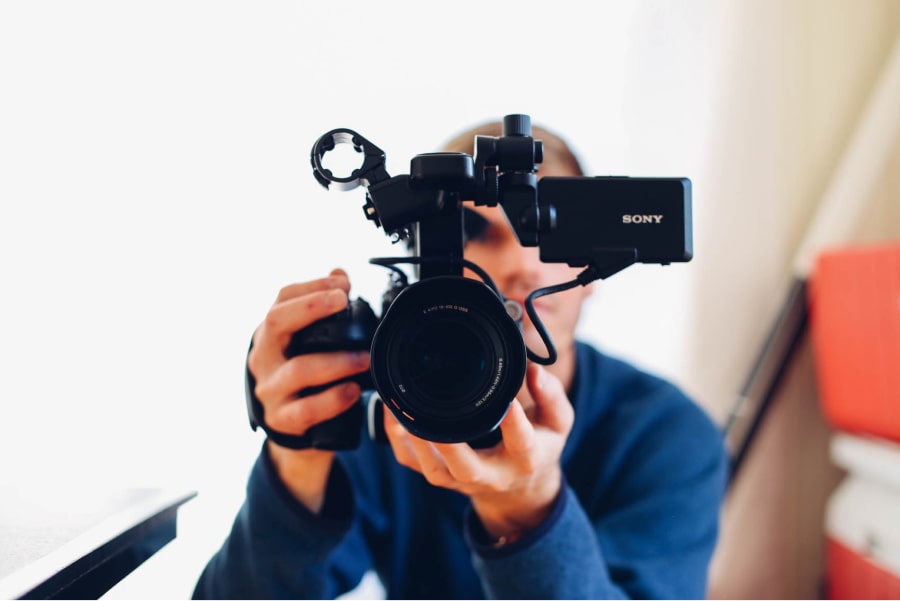 Homem a operar câmara de filmar. Comunicação Visual – O que é e como pode ajudar o seu negócio ou projeto